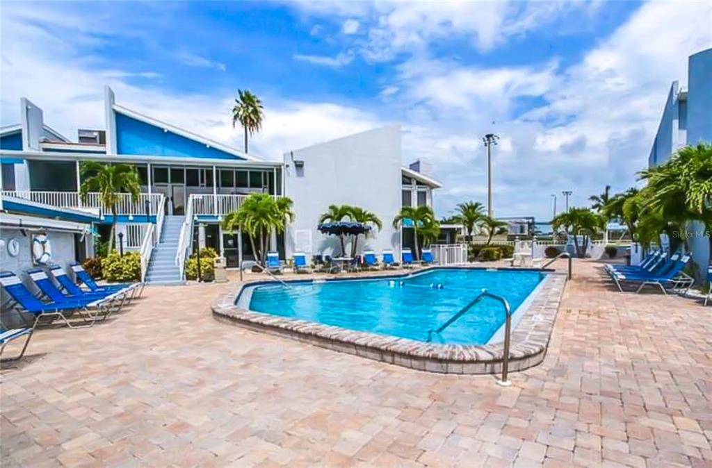 315 Medallion Boulevard, Unit F Madeira Beach, FL 33708 - Photo 18 of 18 a view of a swimming pool with sitting area
