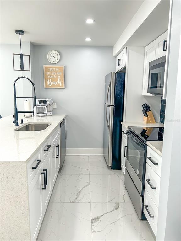 315 Medallion Boulevard, Unit F Madeira Beach, FL 33708 - Photo 5 of 18 a kitchen with a sink stove and refrigerator