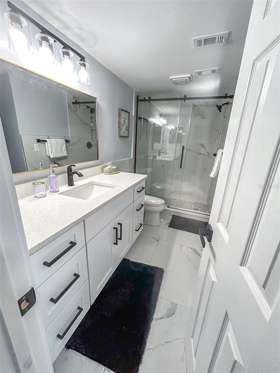 315 Medallion Boulevard, Unit F Madeira Beach, FL 33708 - Photo 8 of 18 a bathroom with a double vanity sink toilet and mirror