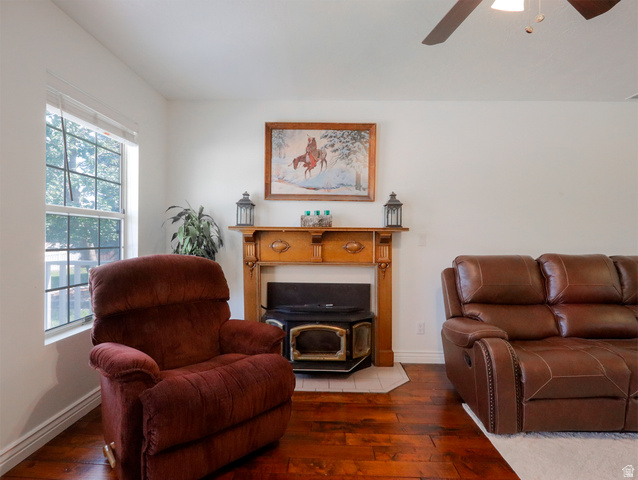 270 East 100 North Monroe, UT 84754 - Photo 11 of 65 Living area featuring warm wood flooring, a decorative wood mantel, and a built-in wood-burning stove