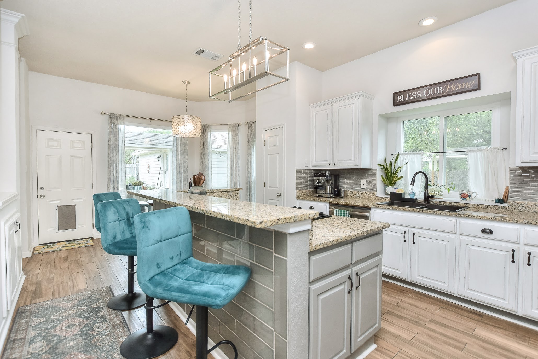 111 Green Grove Georgetown, TX 78633 - Photo 16 of 40 Kitchen featuring white cabinetry, a kitchen bar, light wood-type flooring, decorative backsplash, and a kitchen island