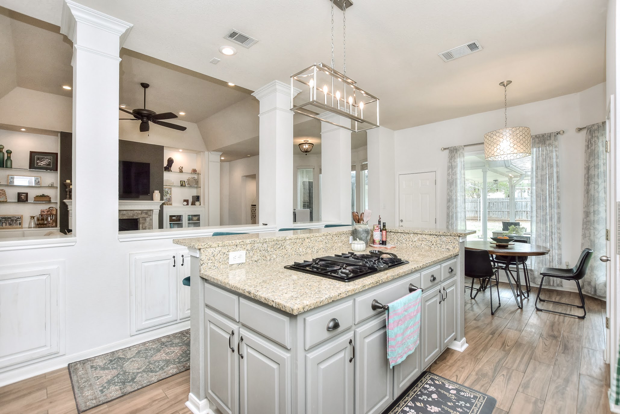 111 Green Grove Georgetown, TX 78633 - Photo 18 of 40 Kitchen featuring light stone countertops, vaulted ceiling, white cabinetry, ceiling fan, and a center island
