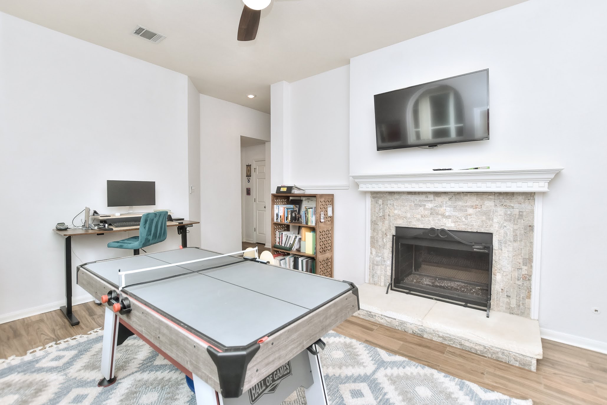 111 Green Grove Georgetown, TX 78633 - Photo 21 of 40 Recreation room featuring light wood-type flooring, an office area, ceiling fan, and a fireplace with raised hearth