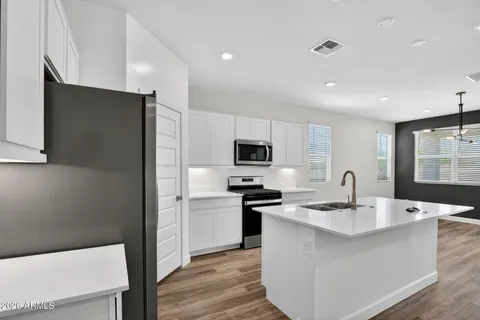 a kitchen with a sink a counter top space stainless steel appliances and cabinets