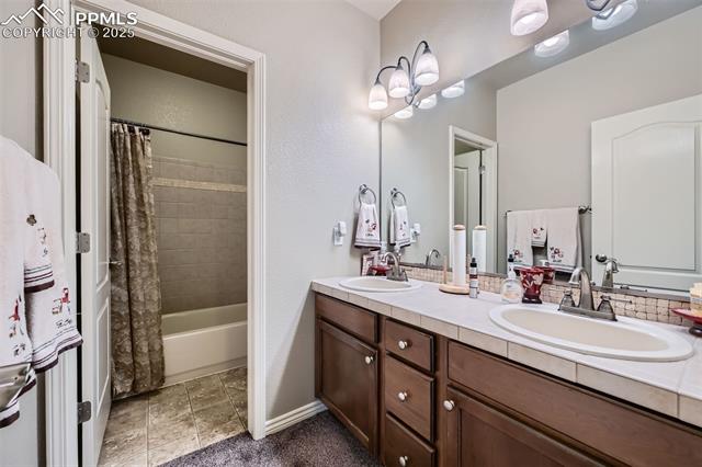 2553 Cinnabar Road Colorado Springs, CO 80921 - Photo 24 of 27 Downstairs full bath featuring double vanity and separate room with shower and toilet