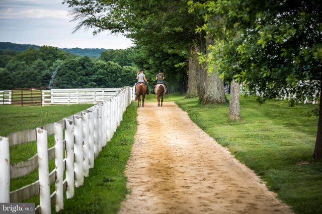 a view of house with a small deck and a wooden fence