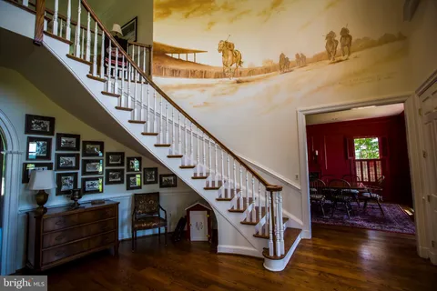 a view of entryway and hall with wooden floor