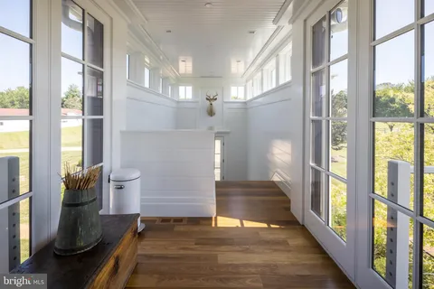 a view of a large pool with lawn chairs and a big yard