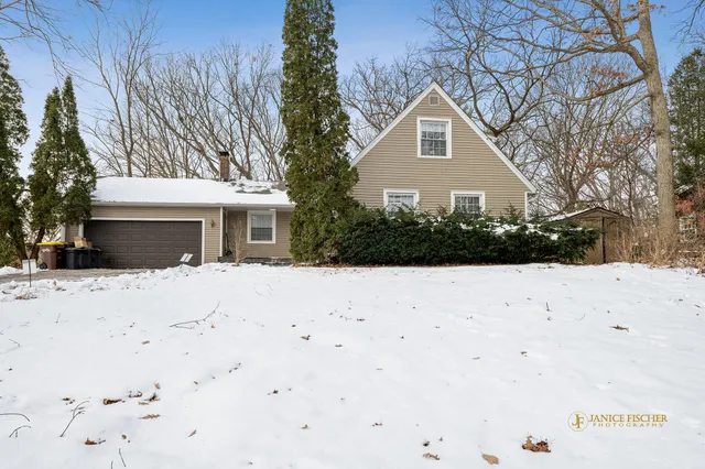 a front view of a house with a yard covered in snow