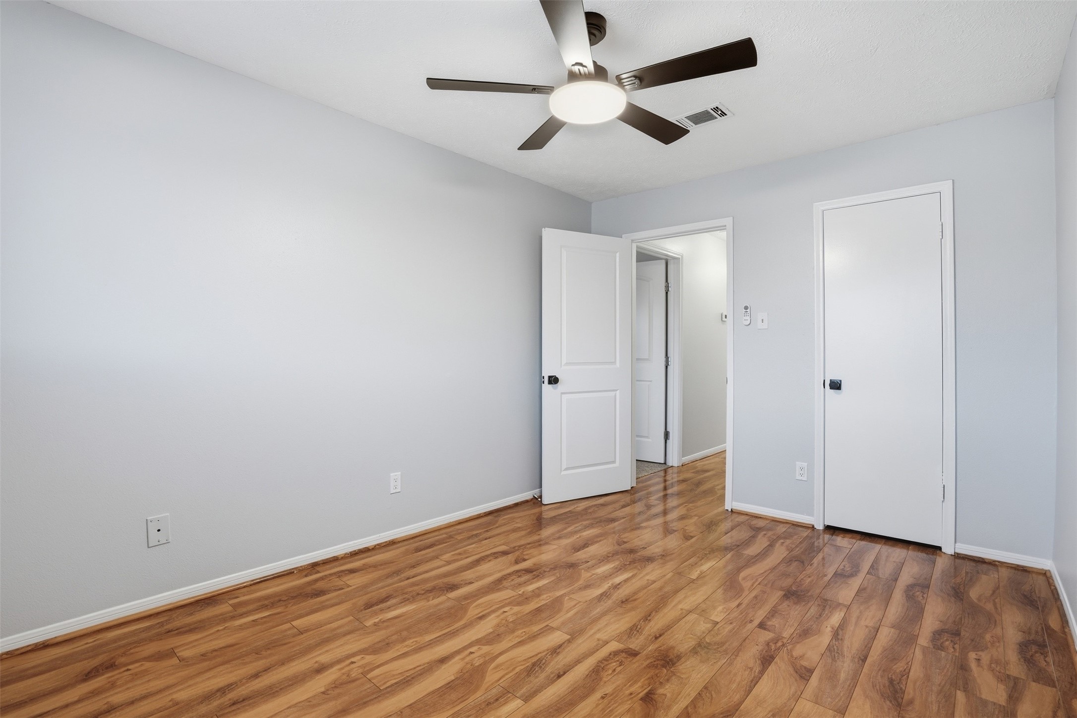 11647 Sabo Road Houston, TX 77089 - Photo 27 of 36 an empty room with wooden floor and ceiling fan