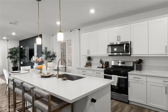 a kitchen with a sink a stove and cabinets