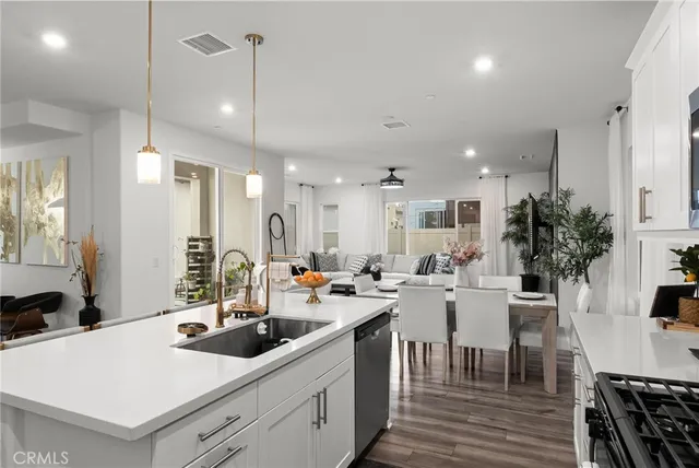 a room with stainless steel appliances kitchen island a table and chairs in it