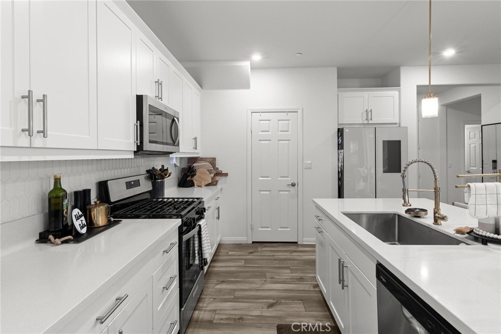352 Alice Avenue Rialto, CA 92376 - Photo 14 of 41 a kitchen with a sink dishwasher a stove and a refrigerator with wooden floor