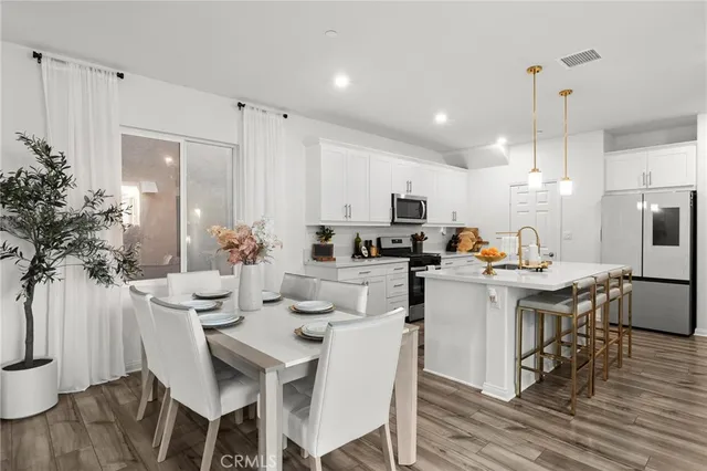 a kitchen with a table chairs stove and white cabinets