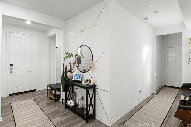 a view of a hallway with wooden floor and entryway