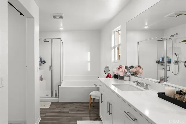a bathroom with a double vanity sink a mirror and a bathtub