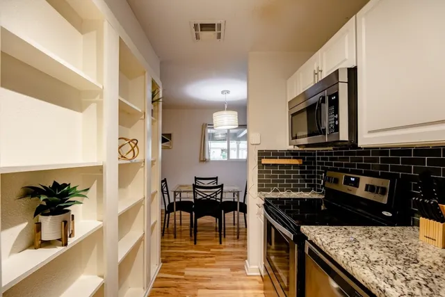 a kitchen with stainless steel appliances granite countertop a stove a sink and a microwave