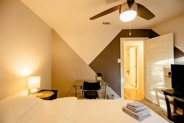 a bedroom with a bed and a flat tv screen on the dresser