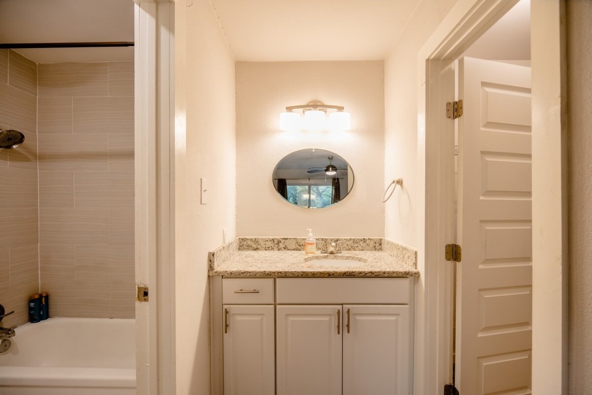 2603 Parker Lane, Unit B Austin, TX 78741 - Photo 19 of 40 a bathroom with a granite countertop sink a mirror and shower