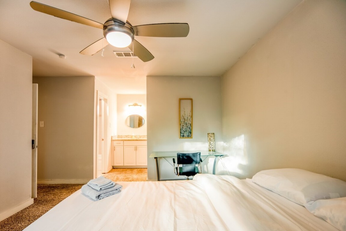 2603 Parker Lane, Unit B Austin, TX 78741 - Photo 20 of 40 a bedroom with a bed and a chandelier