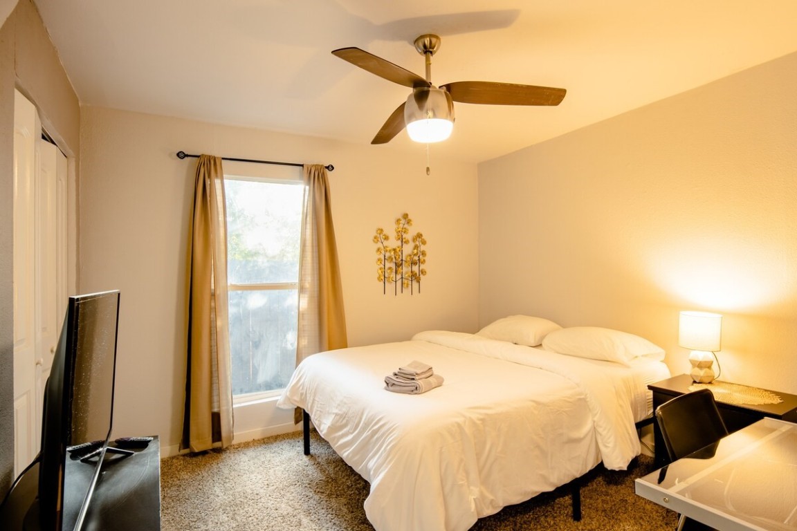 2603 Parker Lane, Unit B Austin, TX 78741 - Photo 21 of 40 a bedroom with a bed and a chandelier