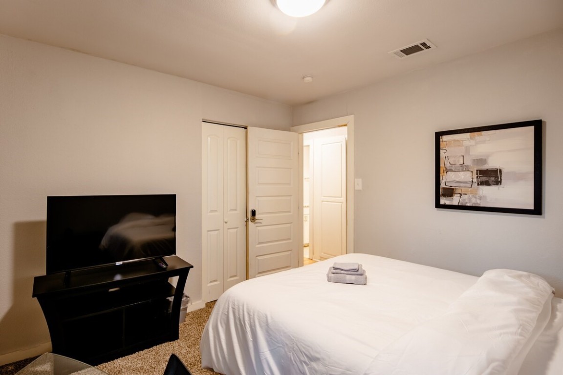 2603 Parker Lane, Unit B Austin, TX 78741 - Photo 32 of 40 a bedroom with a bed and a flat screen tv