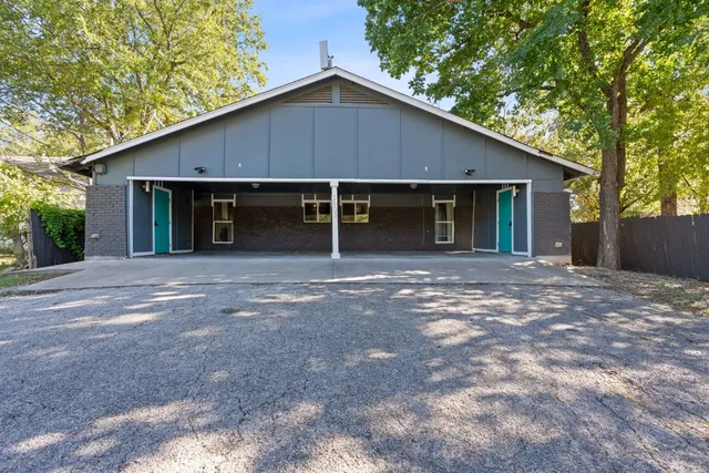 a front view of house with yard and trees in the background