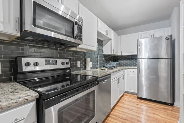 a kitchen with stainless steel appliances granite countertop a stove microwave and refrigerator