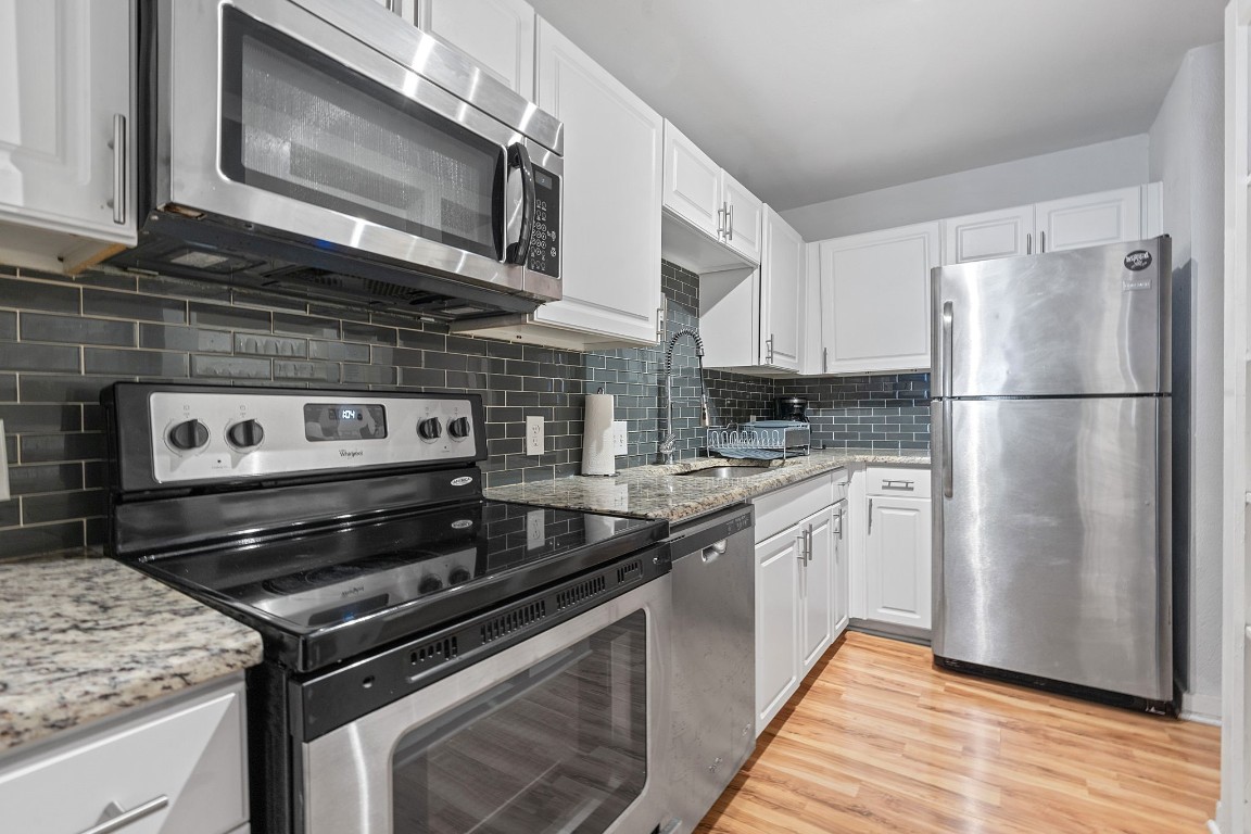 2603 Parker Lane, Unit B Austin, TX 78741 - Photo 36 of 40 a kitchen with stainless steel appliances granite countertop a stove microwave and refrigerator
