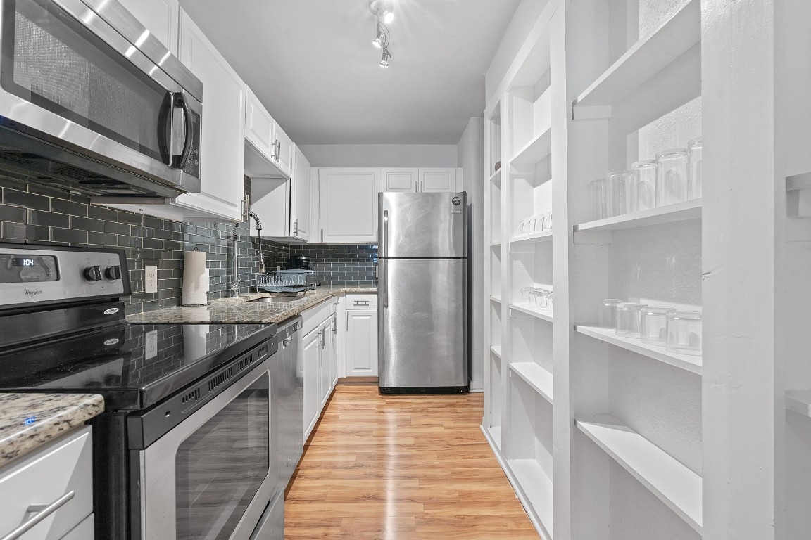 2603 Parker Lane, Unit B Austin, TX 78741 - Photo 4 of 40 a kitchen with stainless steel appliances granite countertop a refrigerator a stove and a sink