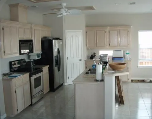 a kitchen with a refrigerator a stove top oven a sink dishwasher and wooden cabinets