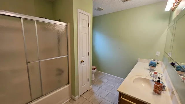 an empty room with a chandelier fan and a window