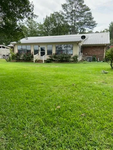 a view of house with ocean and sitting area