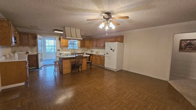 an empty room with chandelier fan and windows