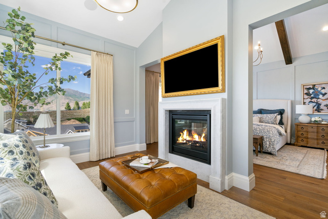 115 East Hidden Ridge Lane, Unit 42 Mapleton, UT 84664 - Photo 22 of 103 Living area featuring a gas fireplace with a stone surround, a large picture window, and wood-finish flooring