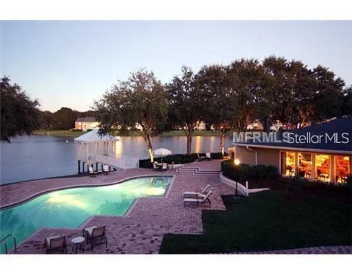 a view of a swimming pool with lawn chairs and a yard