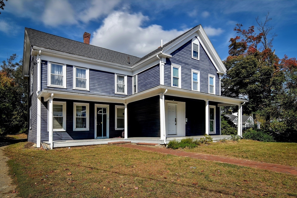 front view of a brick house with a yard