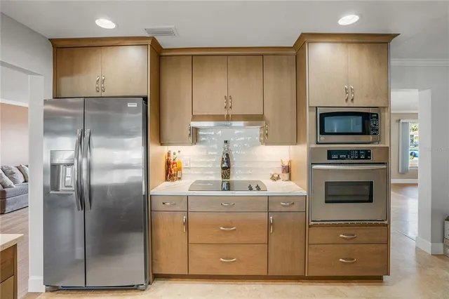 a dining hall with stainless steel appliances kitchen island granite countertop a table and chairs