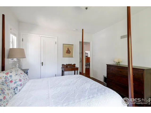 a bedroom with a bed and dresser with mirror