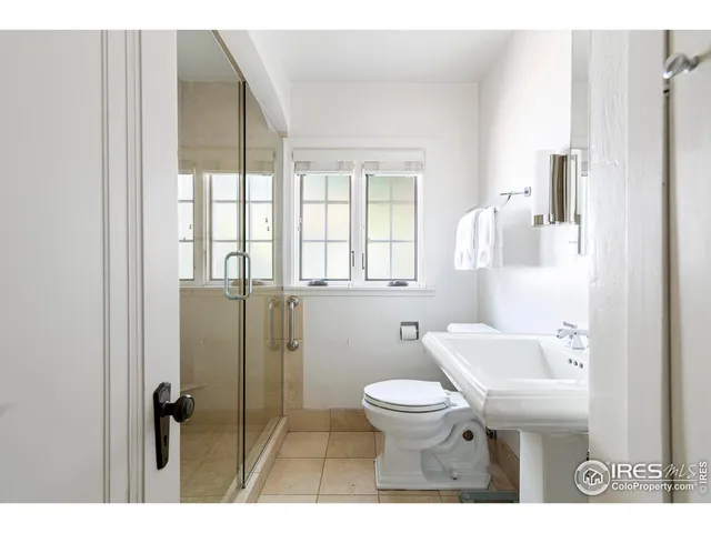 a bathroom with a toilet sink shower and a mirror