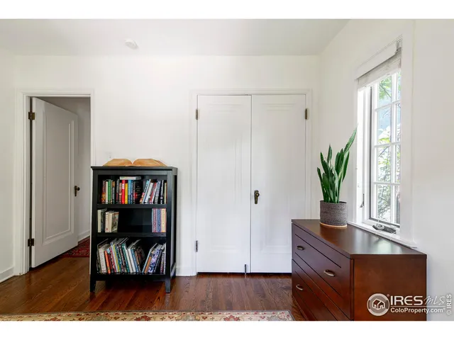 a living room with chair and a book shelf