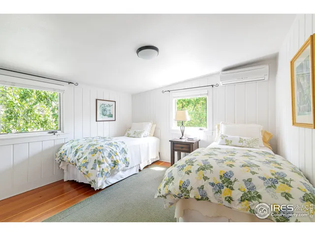 a bedroom with two beds and a large window