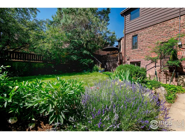 a view of backyard with potted plants and a bench