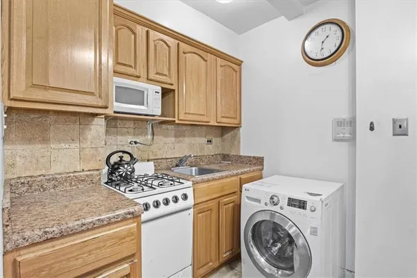 a kitchen with a stove top oven sink and cabinets