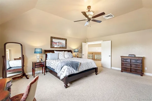 a bed room with a bed and a ceiling fan