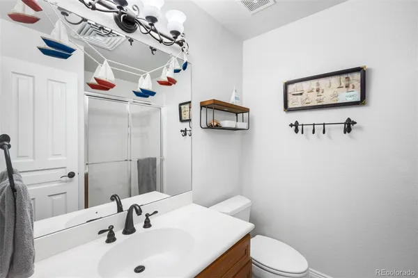 a bathroom with a sink mirror and toilet