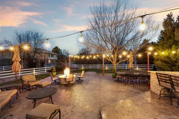 a view of a patio with couches and table and chairs and wooden fence
