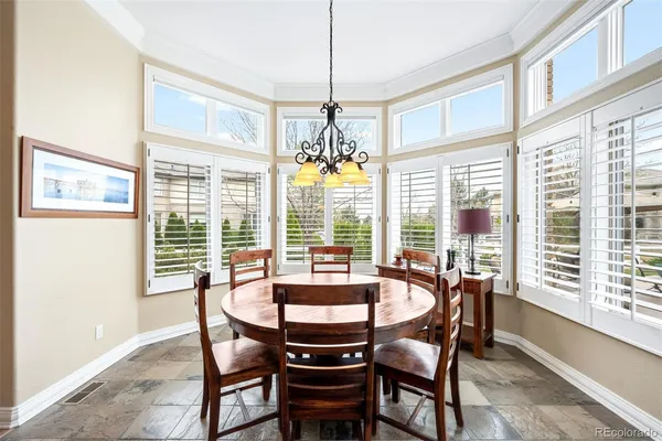 a dining room with furniture a chandelier and wooden floor