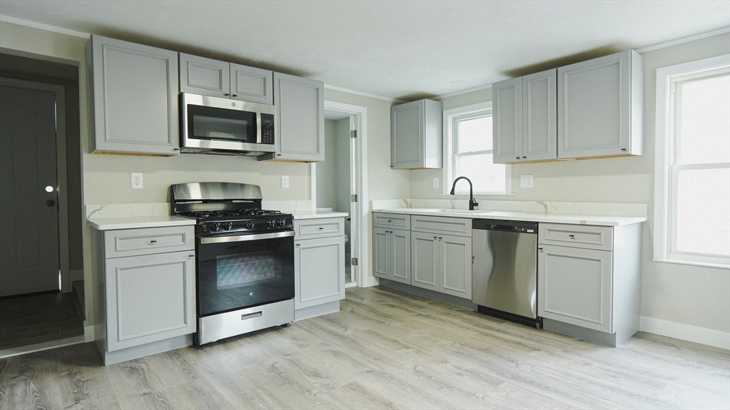 26 Maple Street Spencer, MA 01562 - Photo 16 of 27 a kitchen with stainless steel appliances a sink cabinets and wooden floor