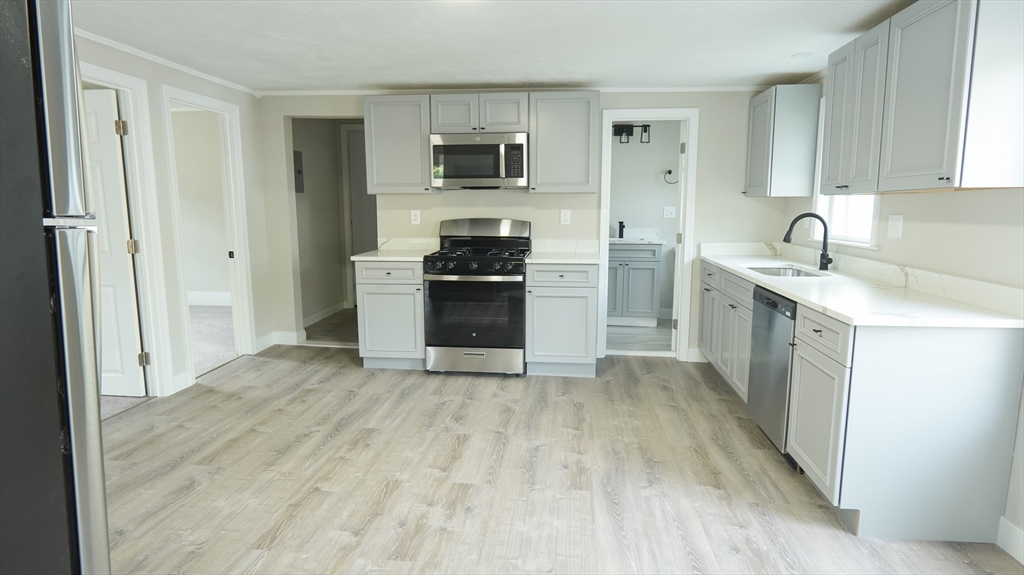 26 Maple Street Spencer, MA 01562 - Photo 17 of 27 a kitchen with a sink a stove top oven and wooden floor